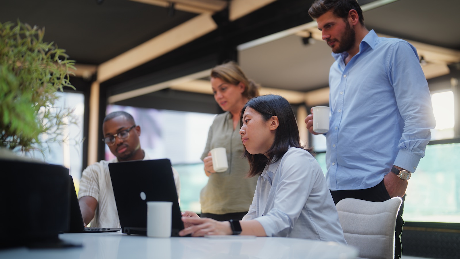 professionals gathered around a computer at a meeting